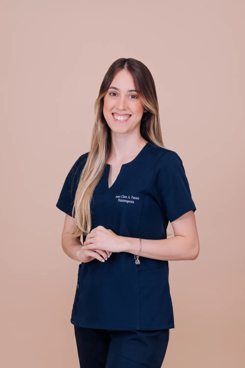 Anna Clara Pataro, fisioterapeuta infantil em Belo Horizonte, com o uniforme profissional bordado com seu nome